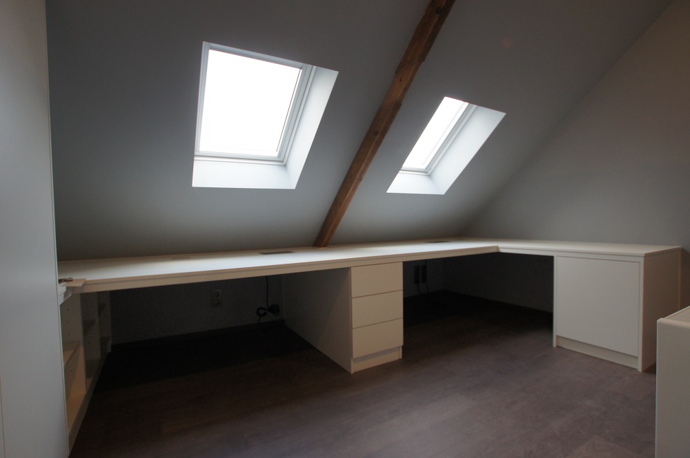 Een bureau op zolder onder een schuin dak