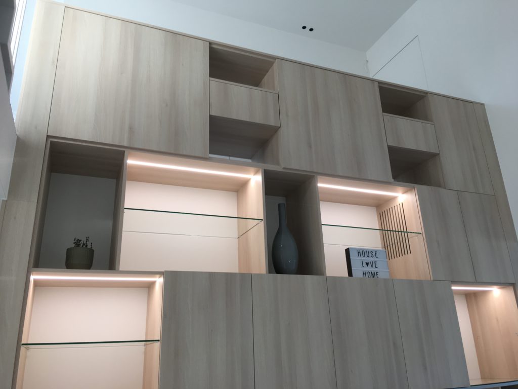 Kastenwand met geïntegreerde LED-verlichting en greeploze kasten.