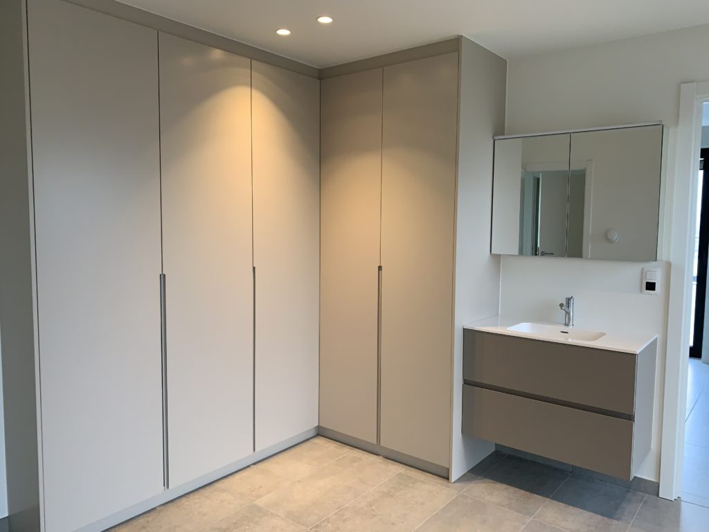 Een badkamer met ingebouwde kasten op maat.