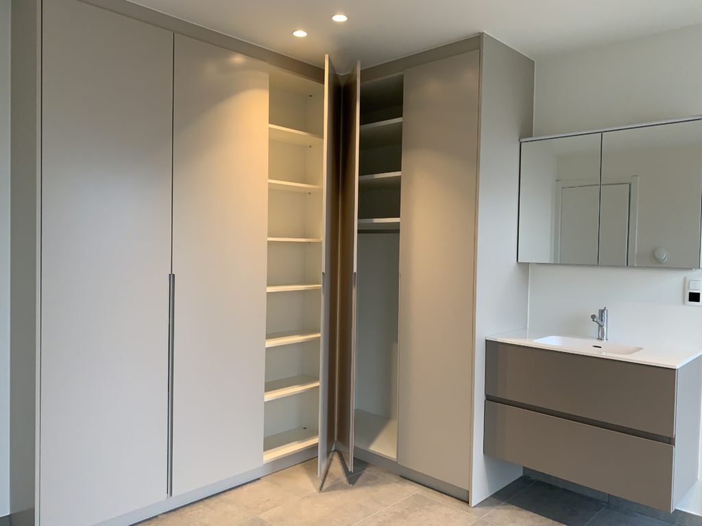 Een badkamer met ingebouwde kasten op maat.