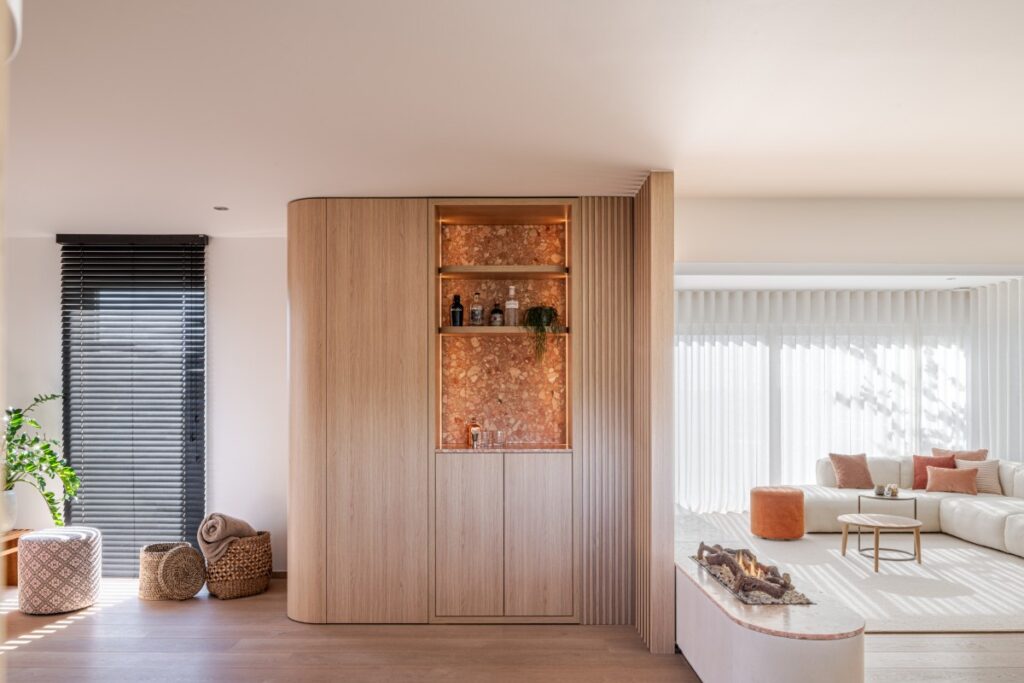 Kast met ingebouwde bar in natuursteen en roomdivider met houten lamellen