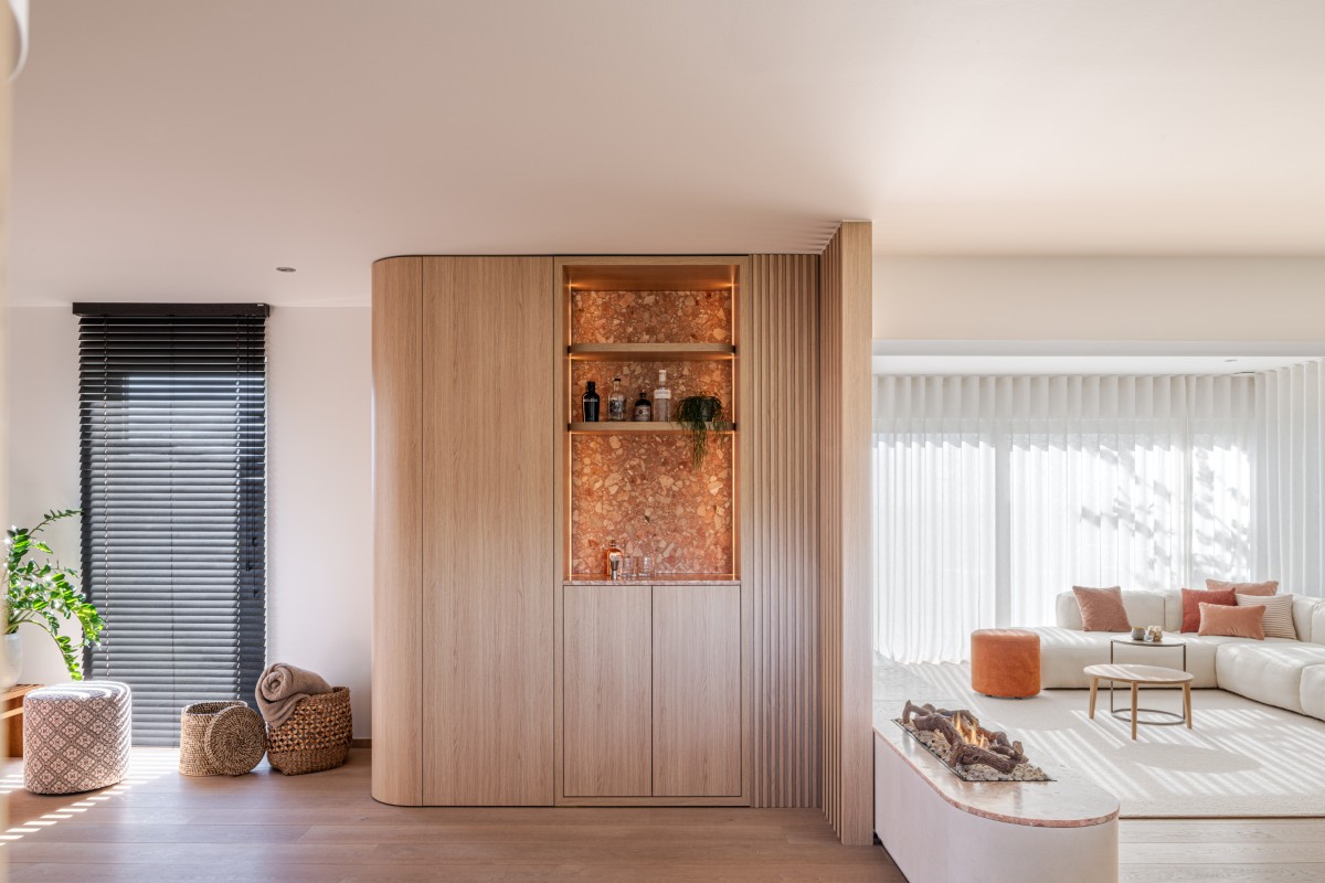 Kast met ingebouwde bar in natuursteen en roomdivider met houten lamellen